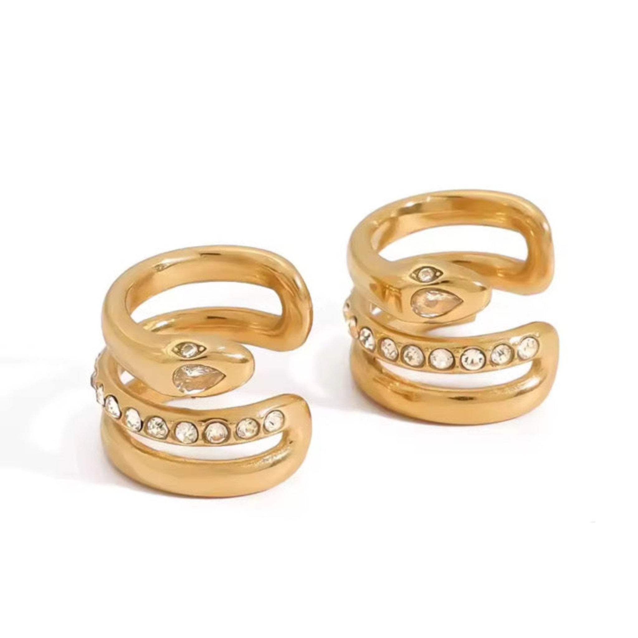 Pair of gold spiral earrings with embedded stones on a white background