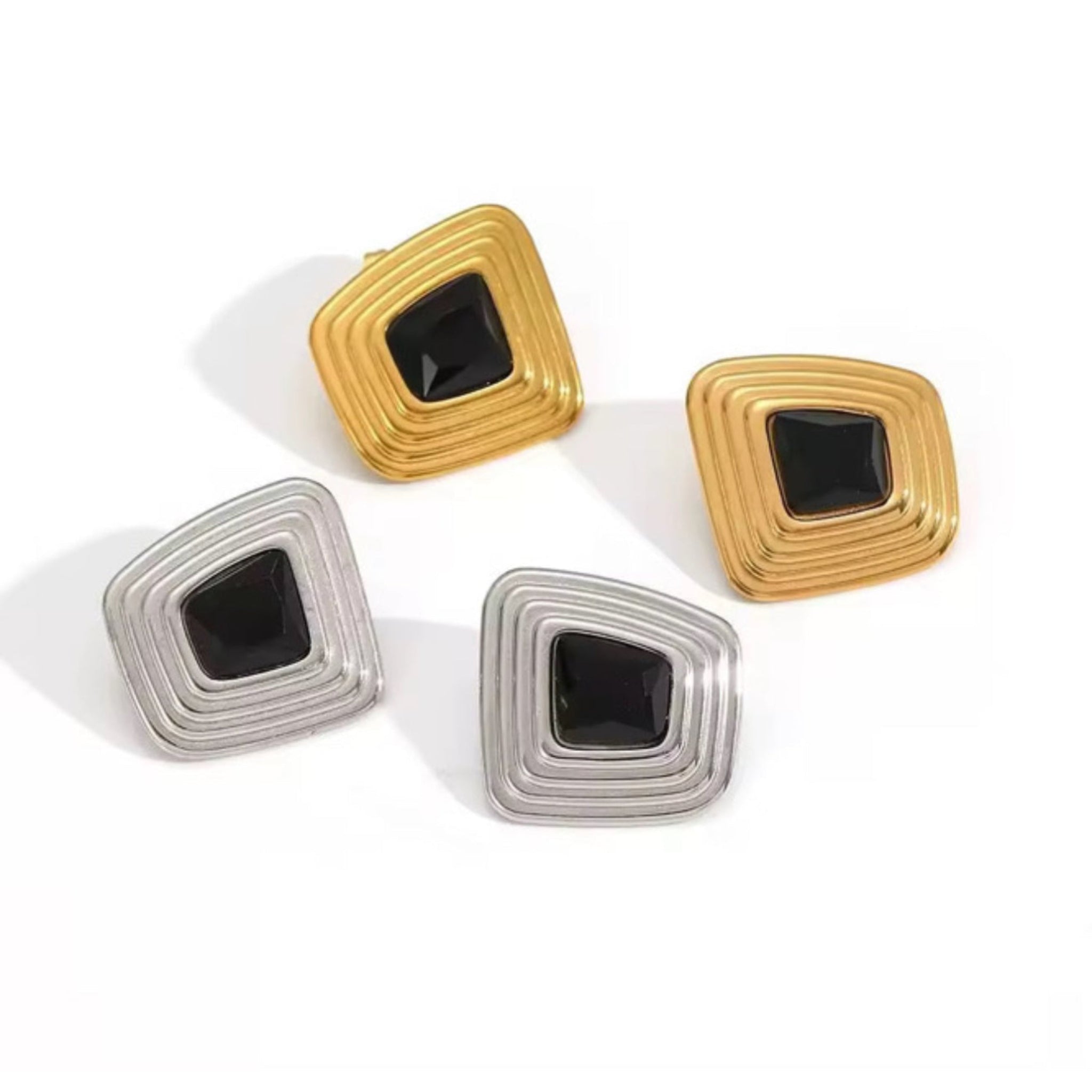 Two pairs of square-shaped earrings in gold and silver on a white background