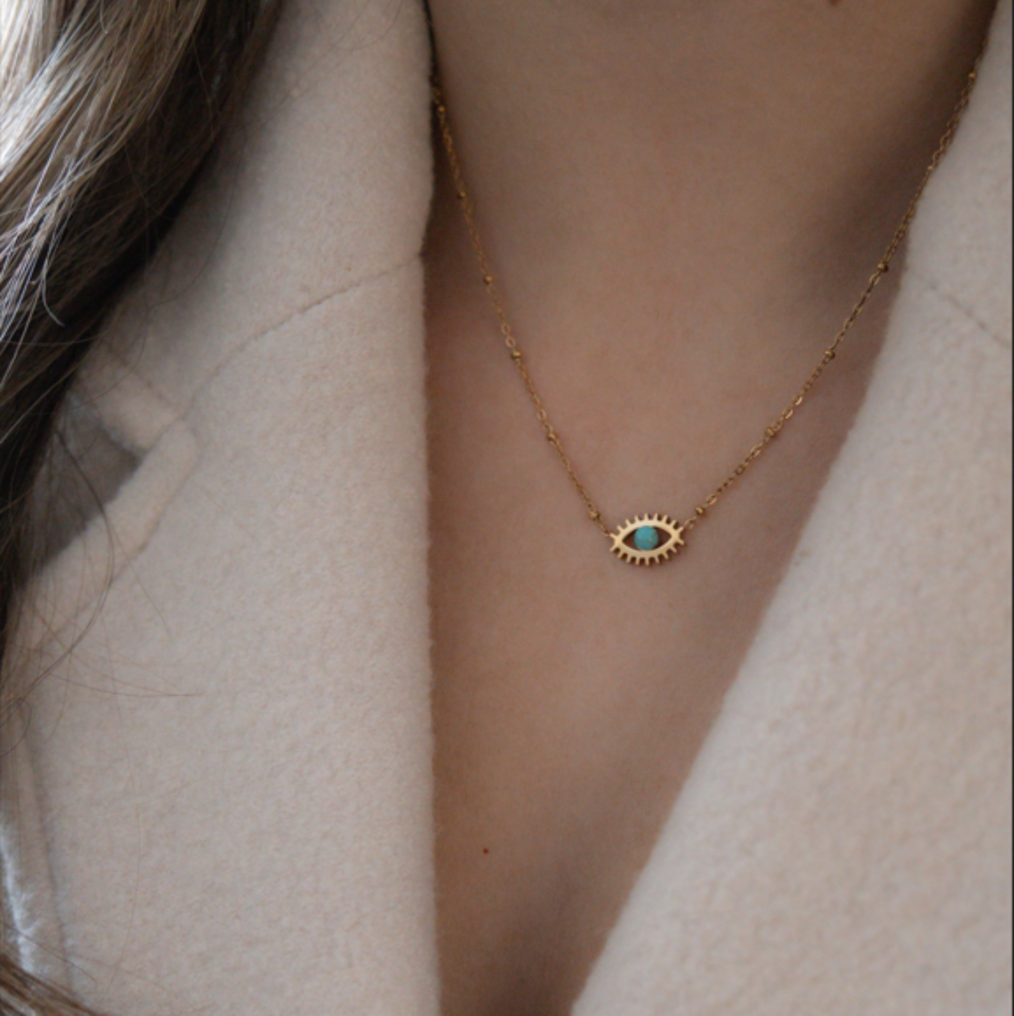 girl wearing evil eye necklace with tortoise eye