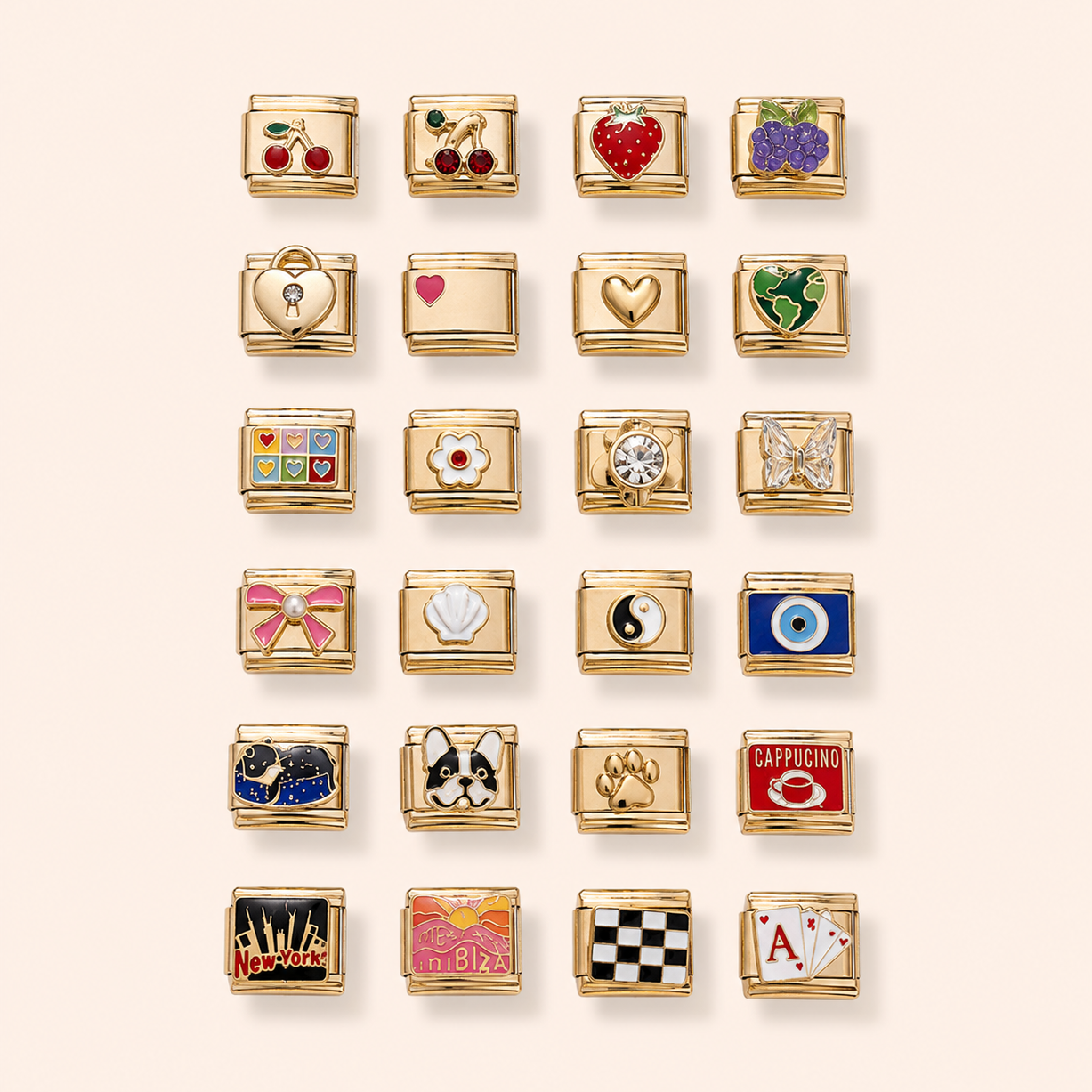 A grid of 24 gold charm links, each featuring a different colorful enamel design such as cherries, hearts, grapes, a key, a shell, a yin-yang symbol, an eye of providence, a cat, a dog, a paw print, a coffee cup, and playing cards, arranged on a light beige background.