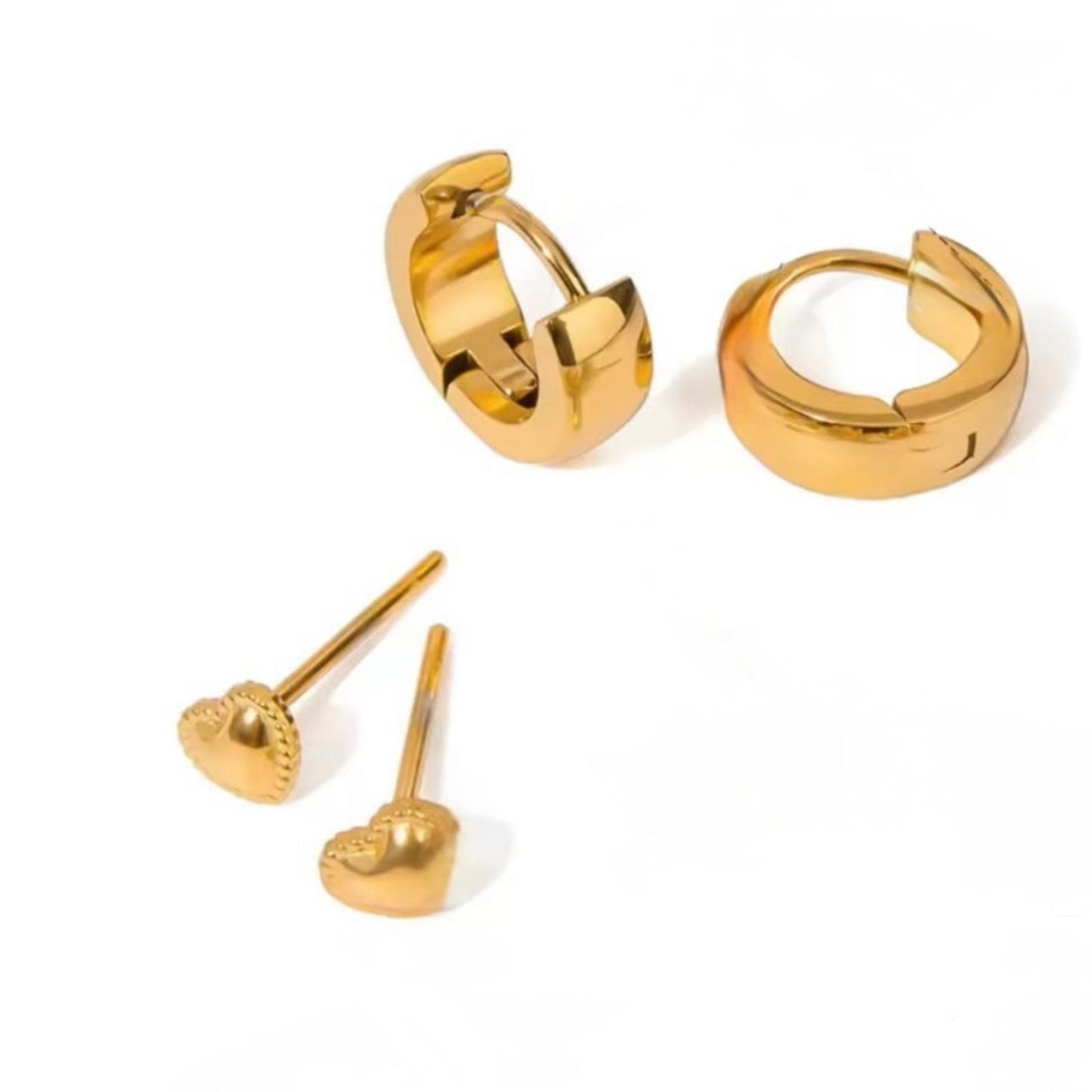 Set of gold hoop earrings and heart-shaped stud earrings on a white background