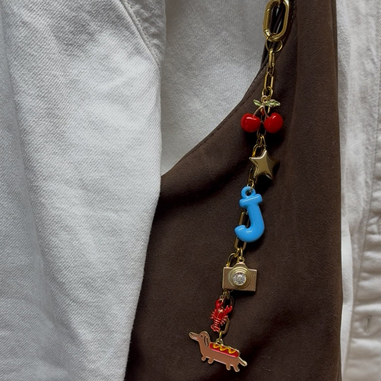 Colorful keychain with various charms attached to a brown jacket.