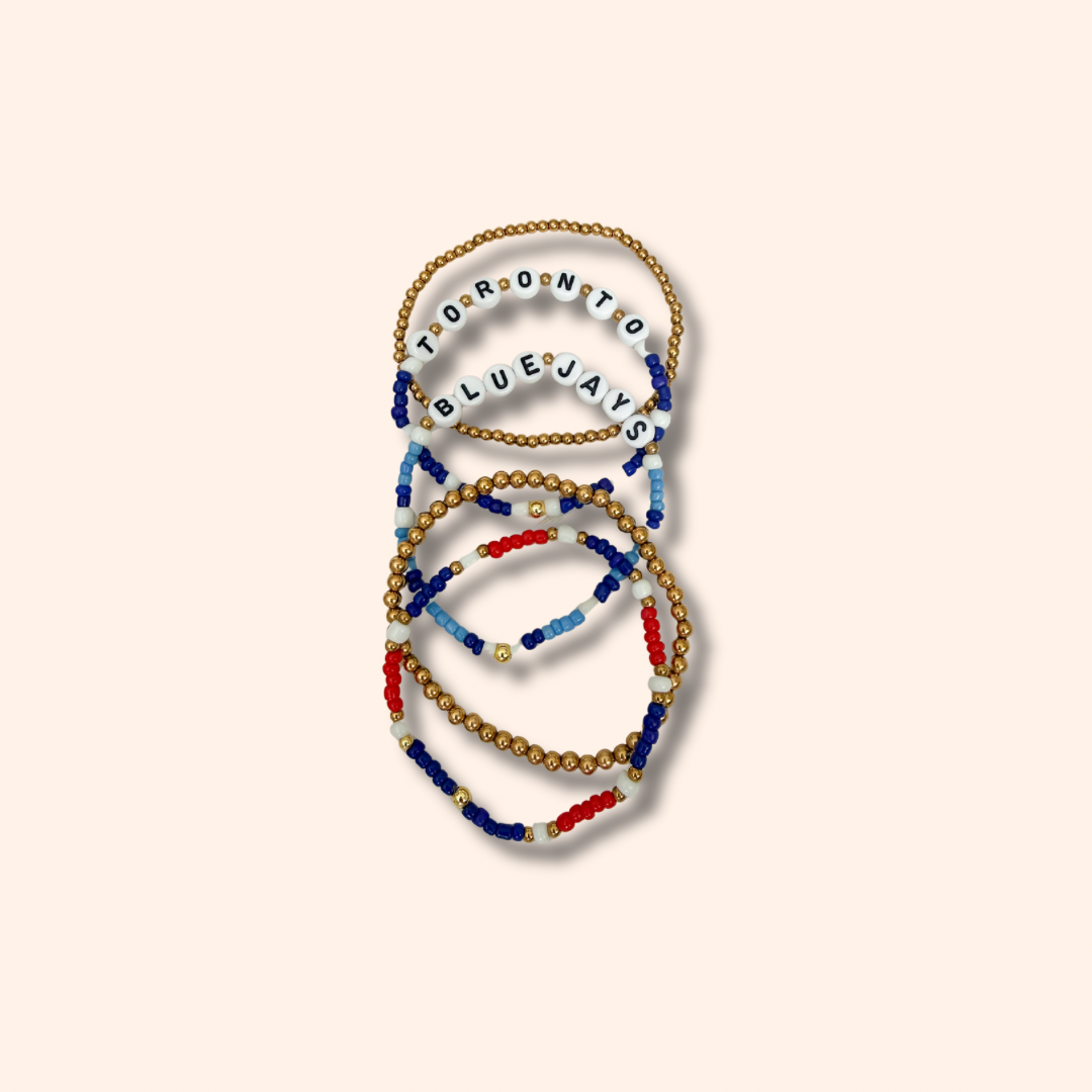 Set of beaded bracelets with 'Toronto Blue Jays' text on a beige background