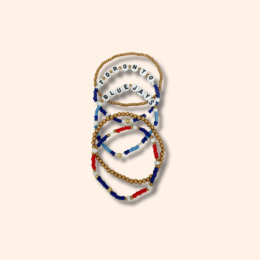 Set of beaded bracelets with 'Toronto Blue Jays' text on a beige background