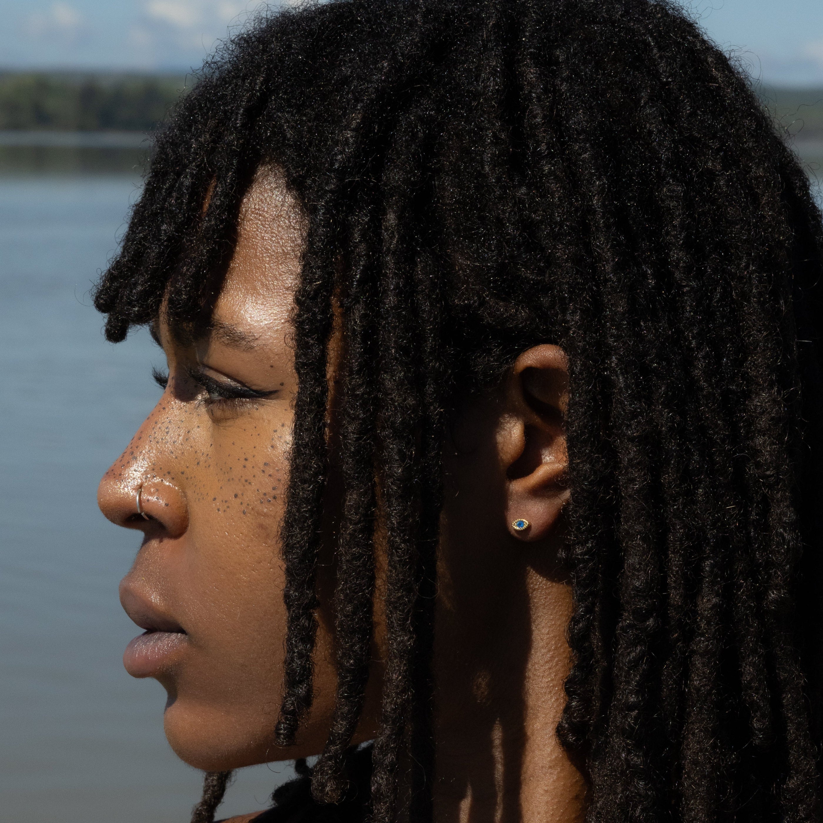 Woman with braided hair standing by a body of water