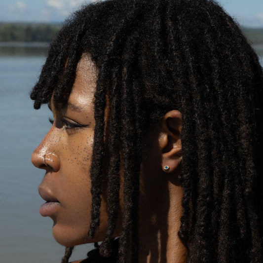Woman with braided hair standing by a body of water