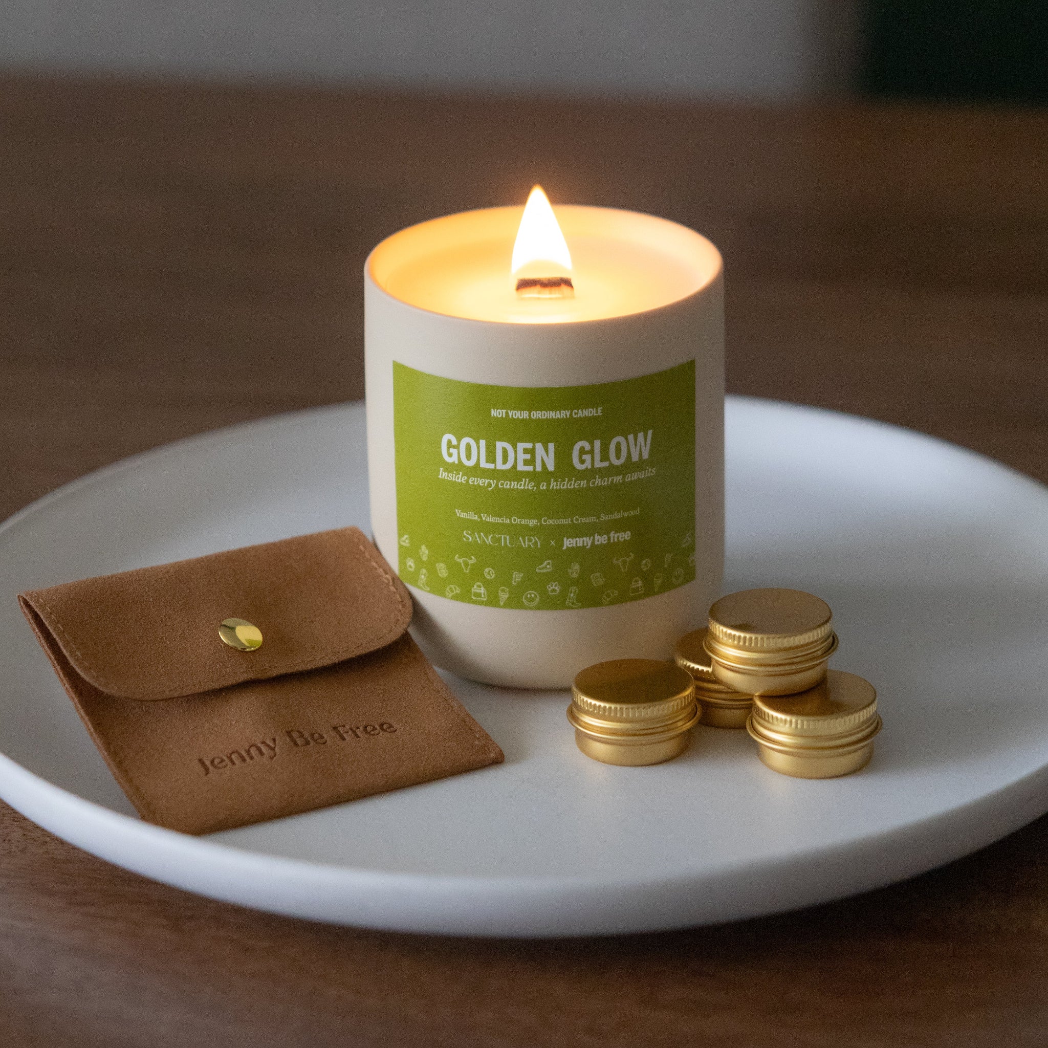 Candle labeled 'Golden Glow' on a white plate with a brown pouch and gold coins.