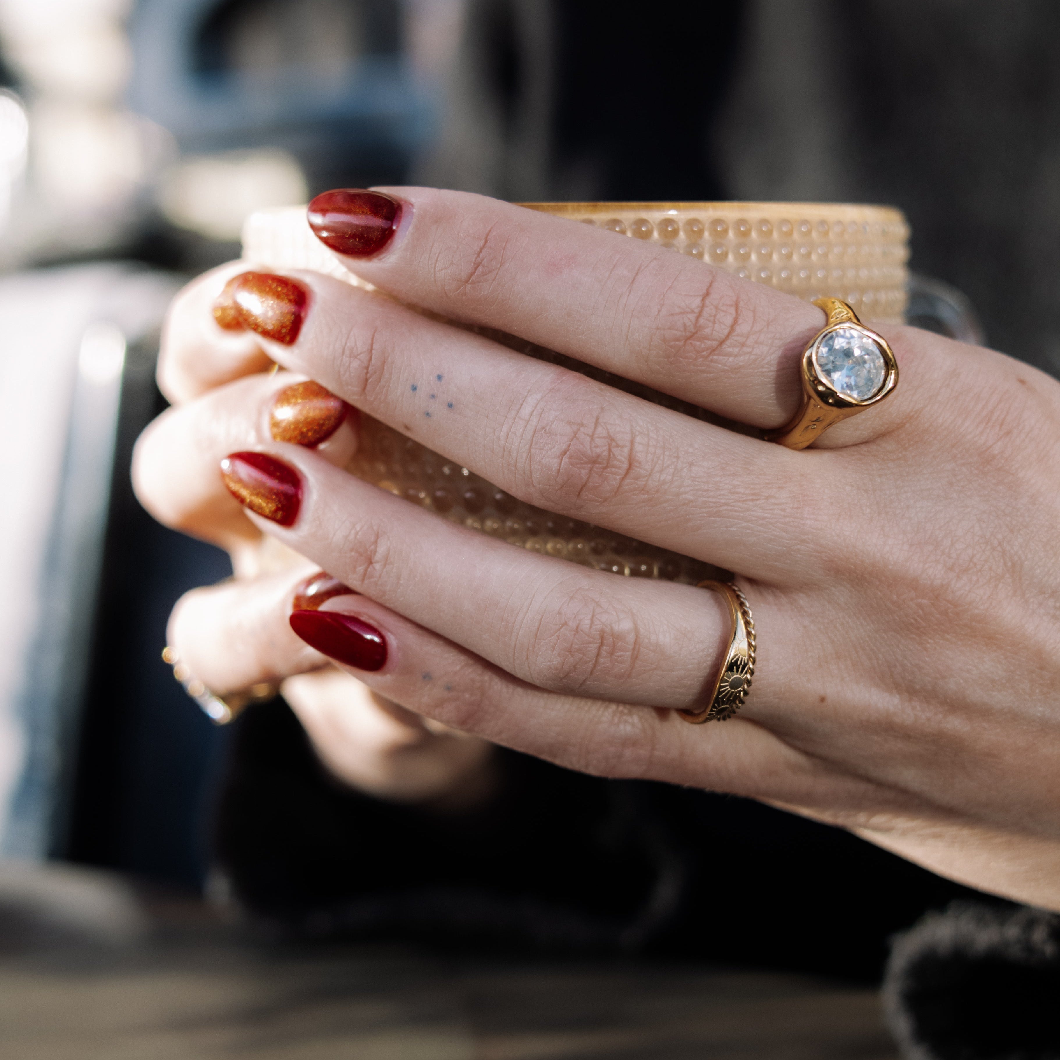 Close-up of a hand holding a coffee cup with a blurred background