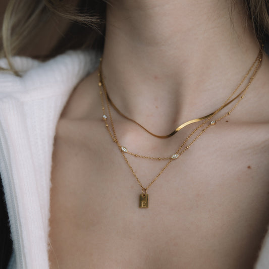 Close-up of a person wearing gold necklaces with a white garment.
