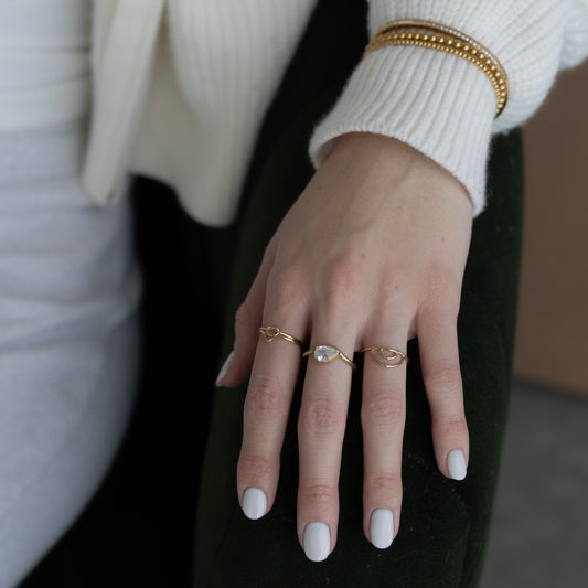 Close-up of a hand wearing multiple rings with a blurred background