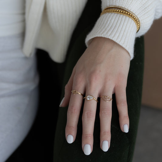 Close-up of a hand wearing multiple rings with a blurred background