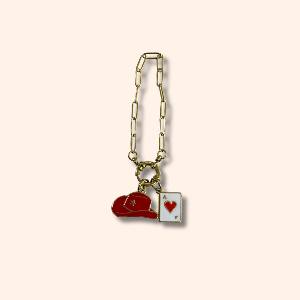 Gold chain with two charms on a beige background