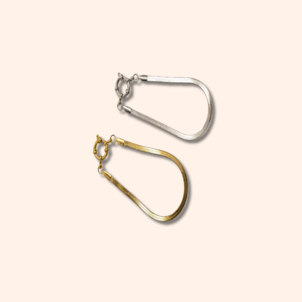 Gold and silver hoop earrings on a beige background
