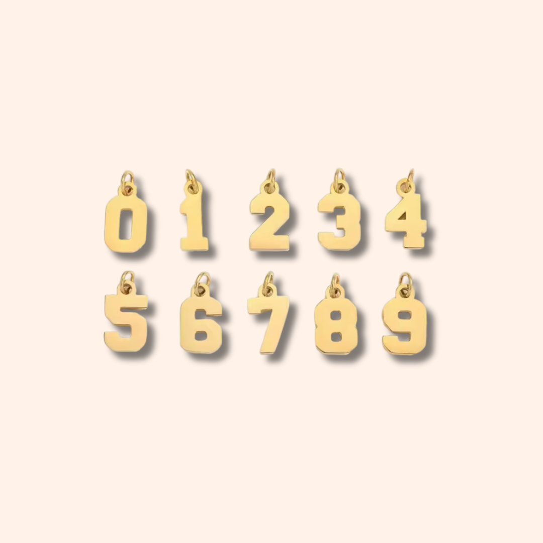 Gold number charms on a beige background