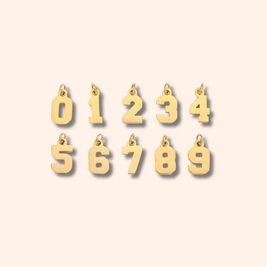 Gold number charms on a beige background