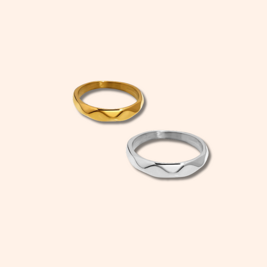 Two gold and silver rings on a beige background