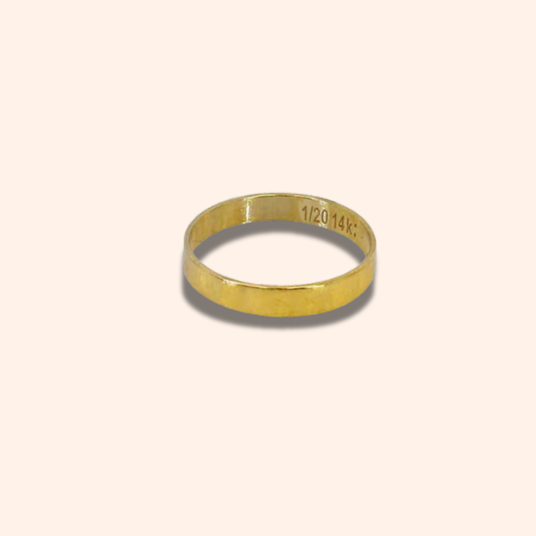 Gold ring with engraved text on a beige background