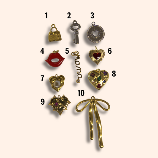 Collection of gold jewelry charms on a beige background