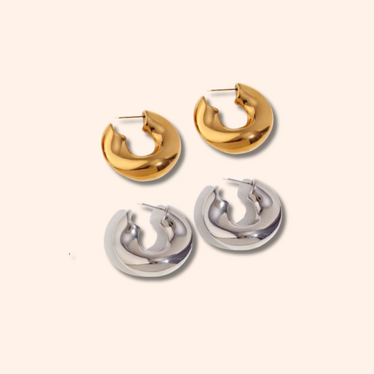 Pair of gold hoop earrings and a pair of silver hoop earrings on a white background