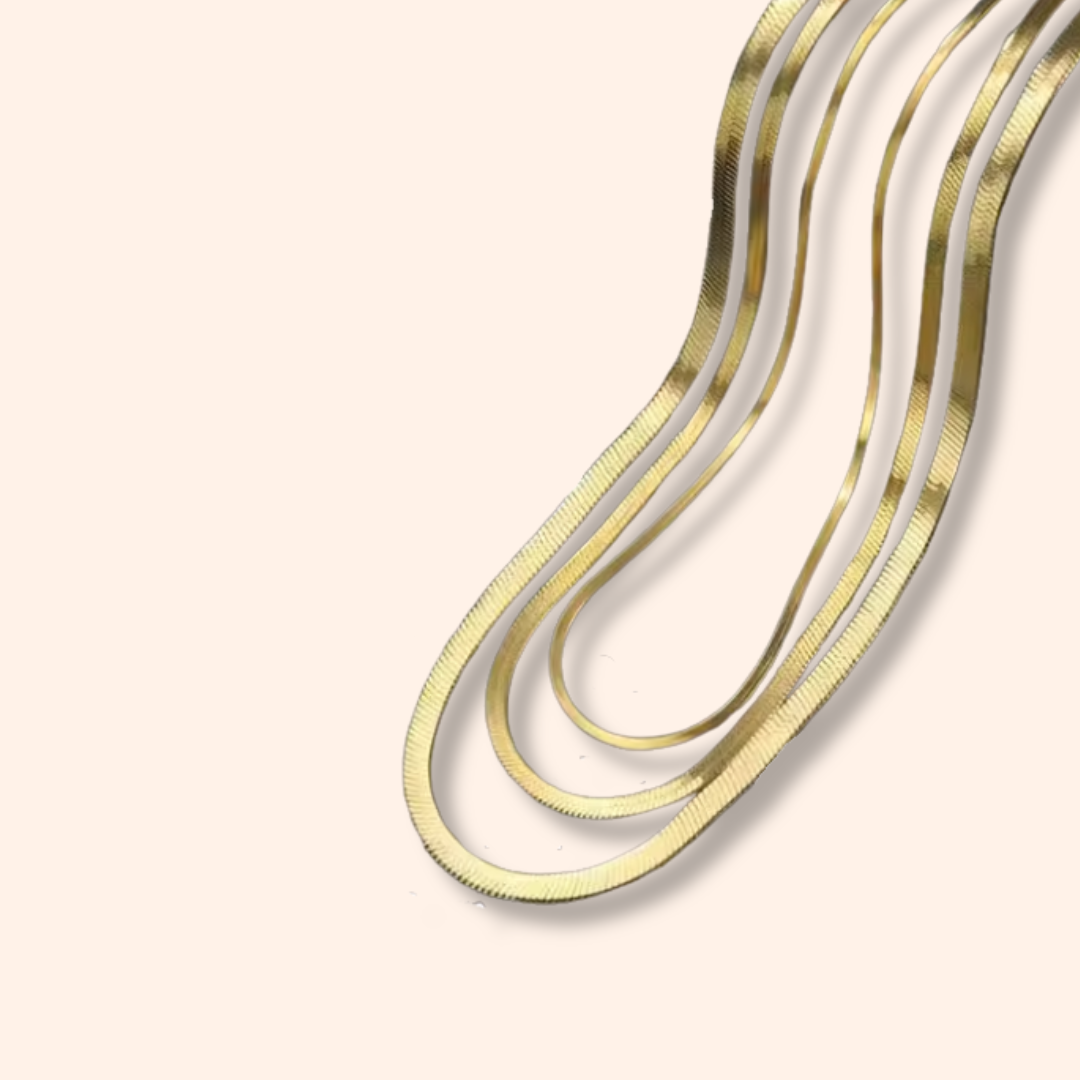 Gold and silver necklaces on a beige background