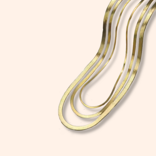 Gold and silver necklaces on a beige background