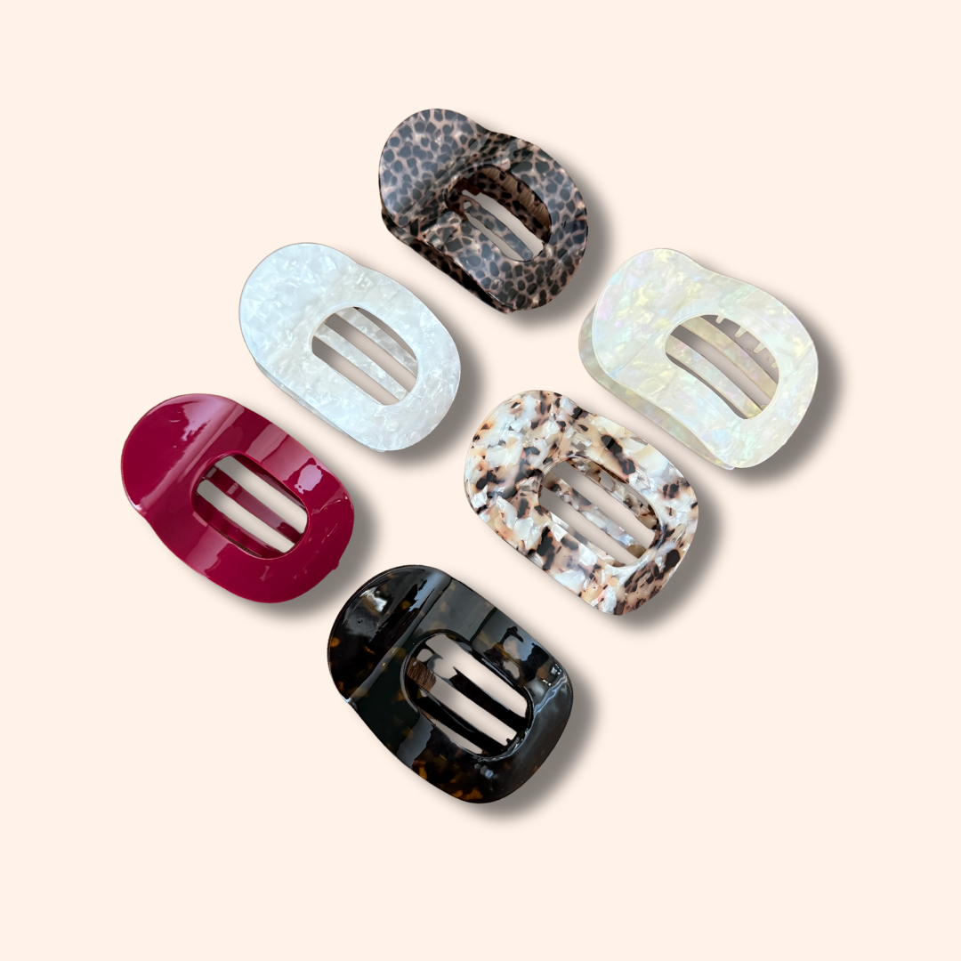 Set of six colorful hair clips on a beige background