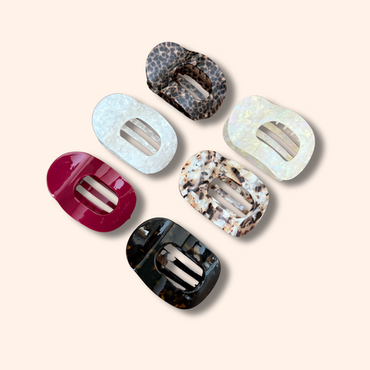 Set of six colorful hair clips on a beige background