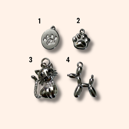 Four silver animal-themed pendants on a beige background