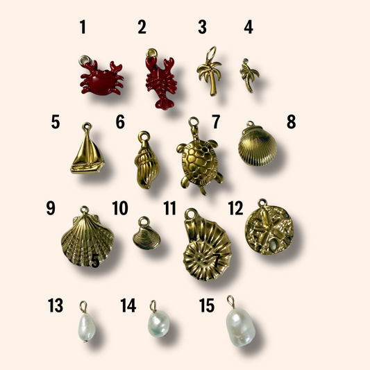 Collection of various jewelry charms on a beige background