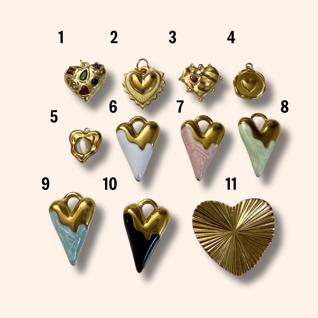 Collection of heart-shaped jewelry pieces with various designs and colors on a light background.