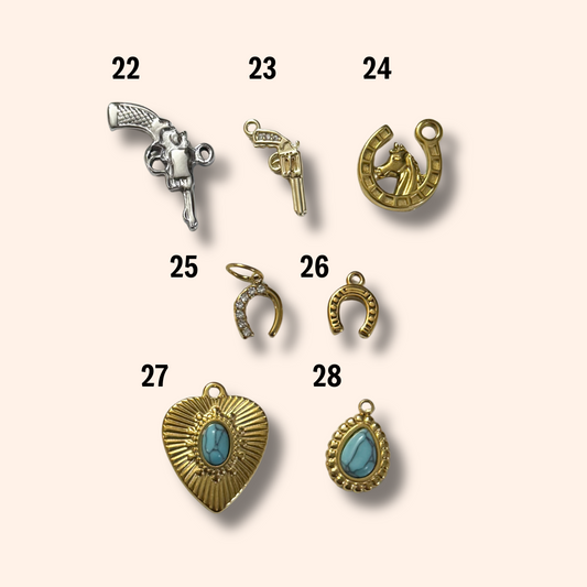 Collection of various jewelry charms on a beige background