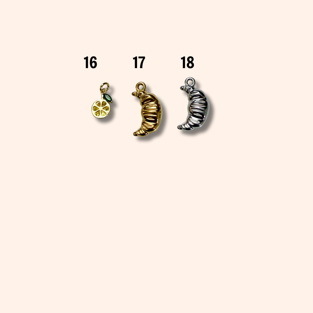 Three moon-shaped charms on a beige background