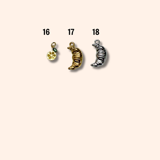 Three moon-shaped charms on a beige background