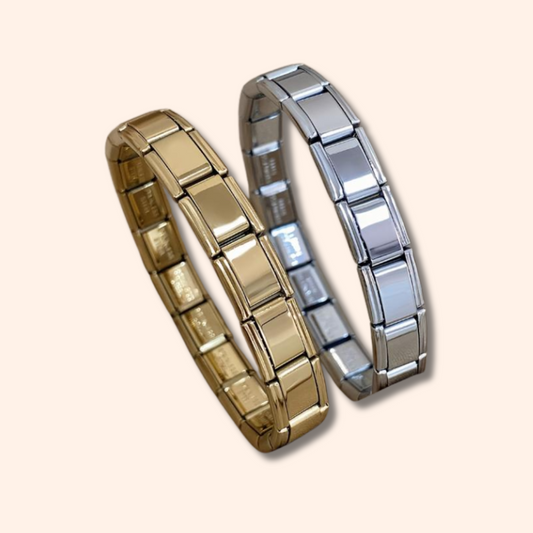 Two metallic bracelets, one gold and one silver, on a beige background.