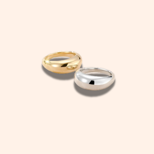Two gold and silver rings on a beige background