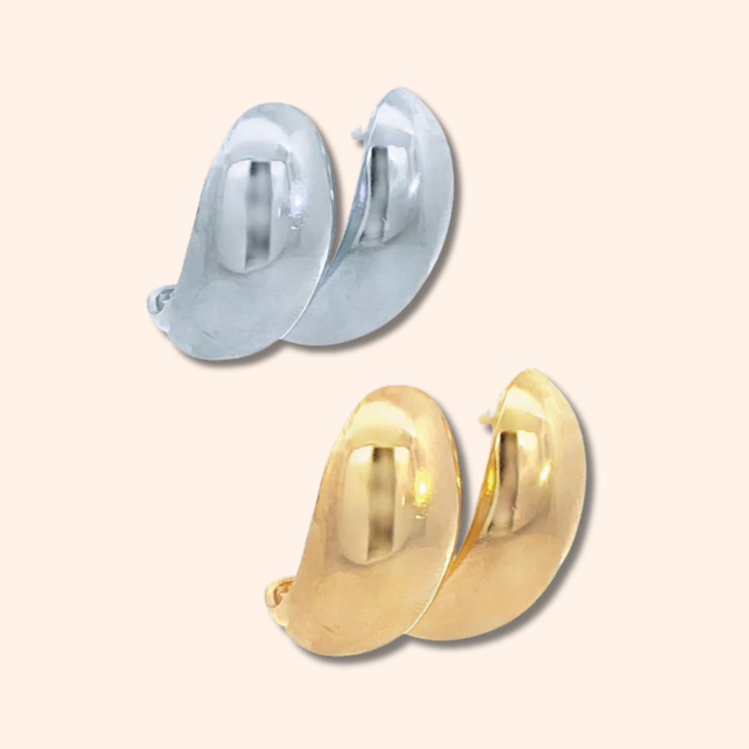 Gold and silver hoop earrings on a light beige background