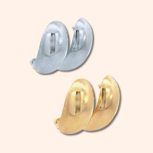 Gold and silver hoop earrings on a light beige background