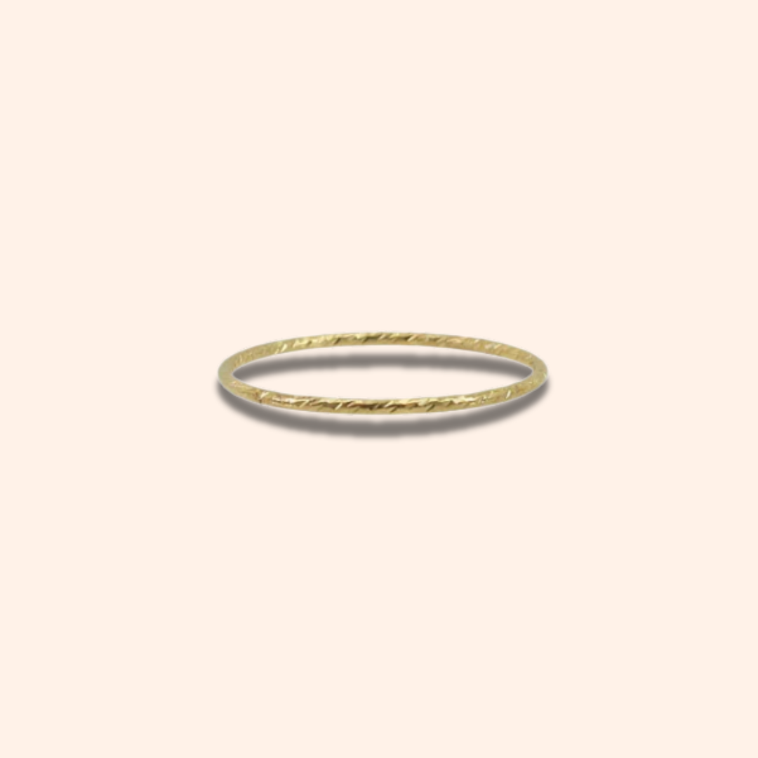 Gold ring on a light beige background