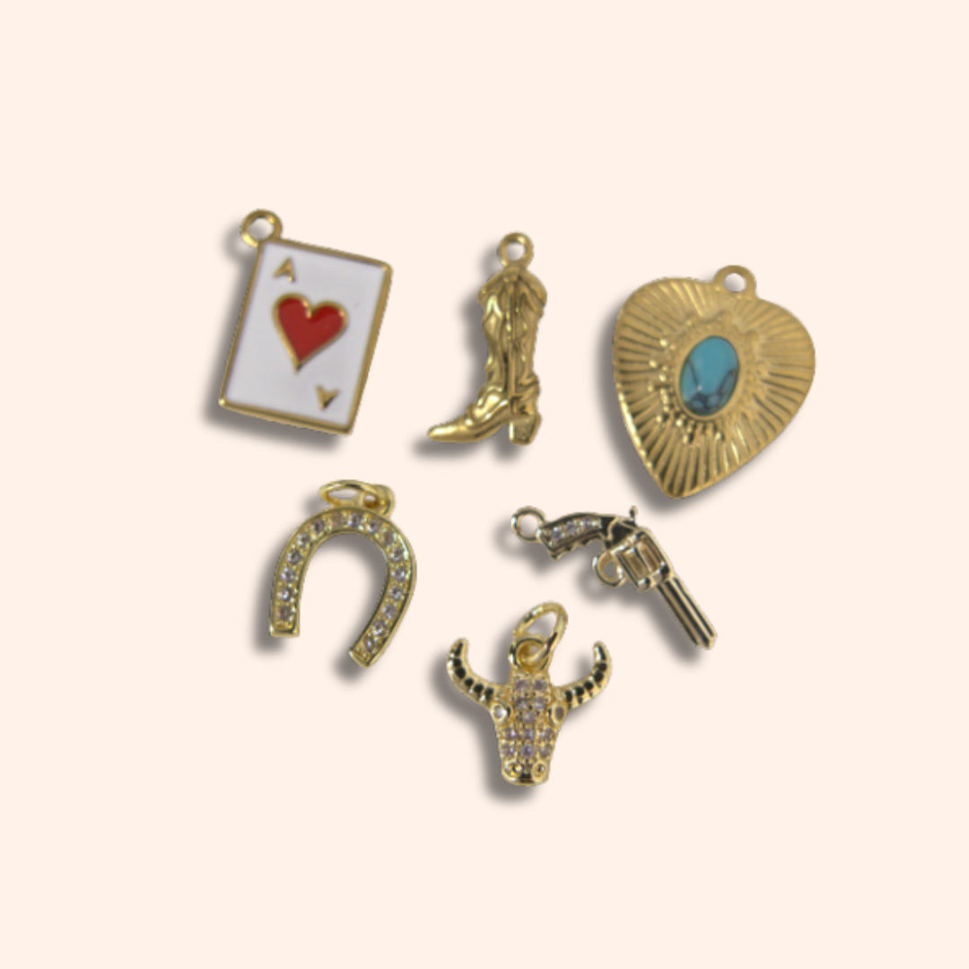 Collection of gold-themed charms on a light beige background