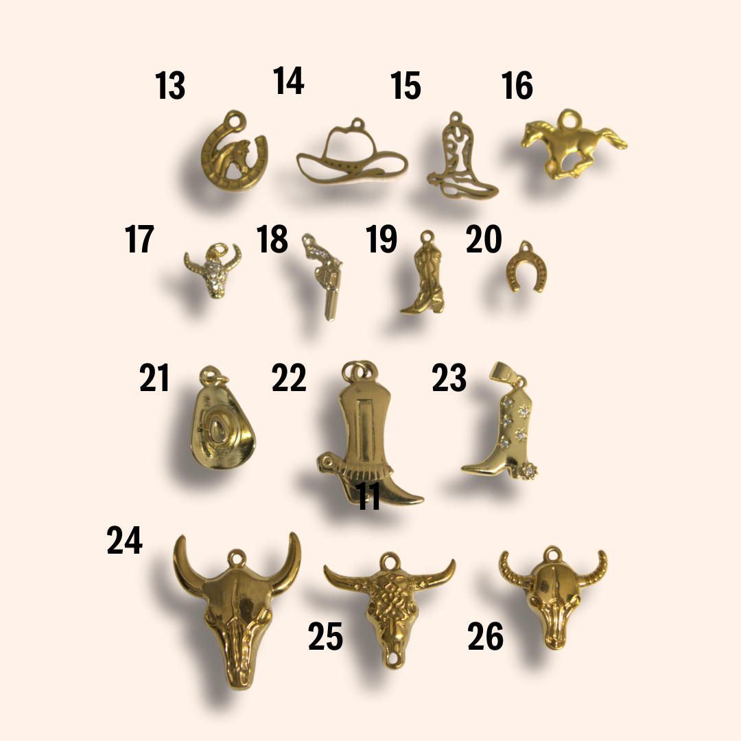 Collection of gold jewelry charms on a beige background