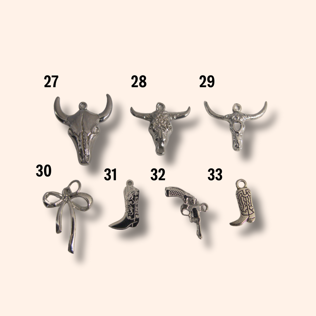 Collection of silver charms on a beige background