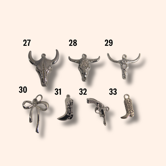 Collection of silver charms on a beige background
