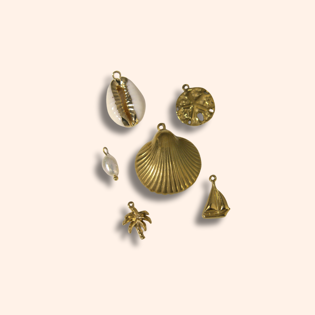Set of gold-themed jewelry charms on a beige background