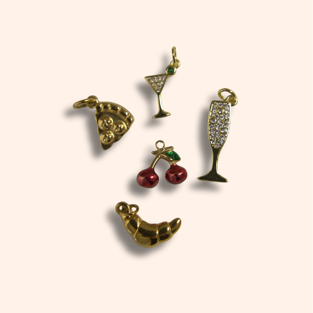 Set of five gold-themed charms on a beige background