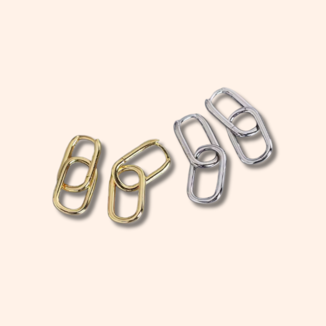 Four metal links in gold, silver, and bronze on a beige background
