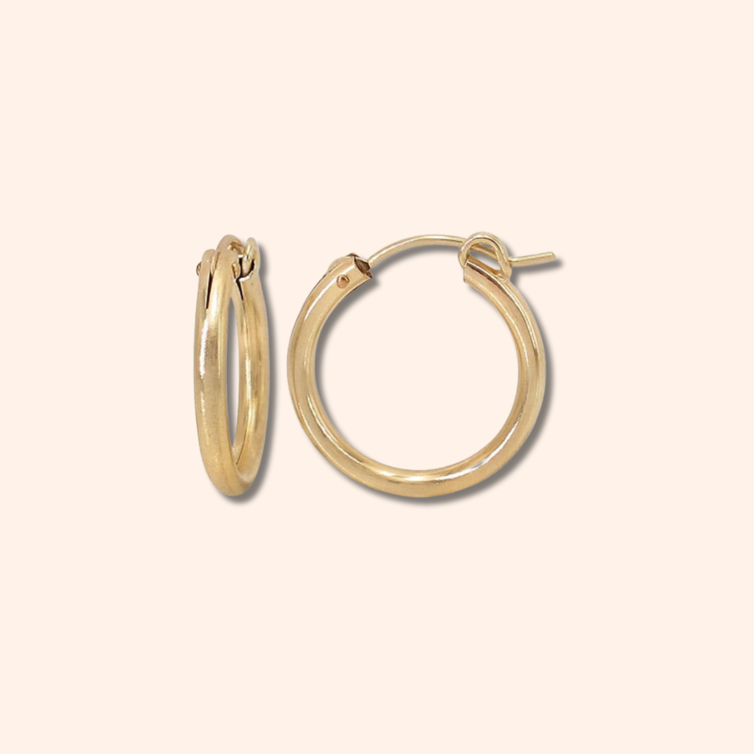 Gold hoop earrings on a beige background