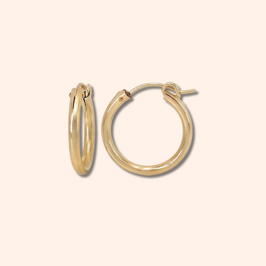 Gold hoop earrings on a beige background
