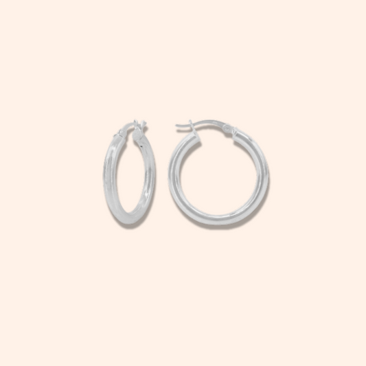 Pair of silver hoop earrings on a beige background