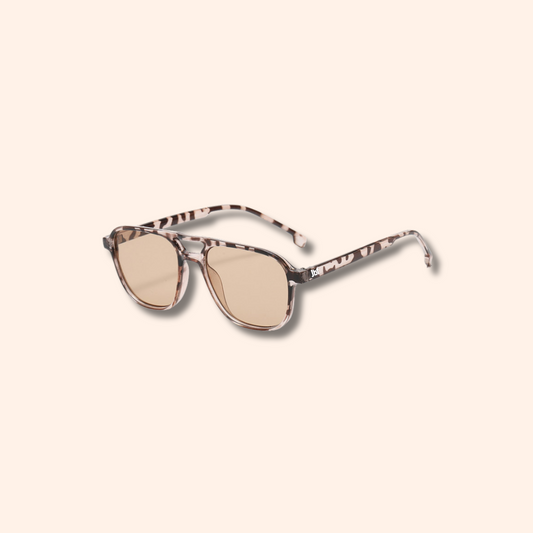 Sunglasses with a leopard print frame on a beige background