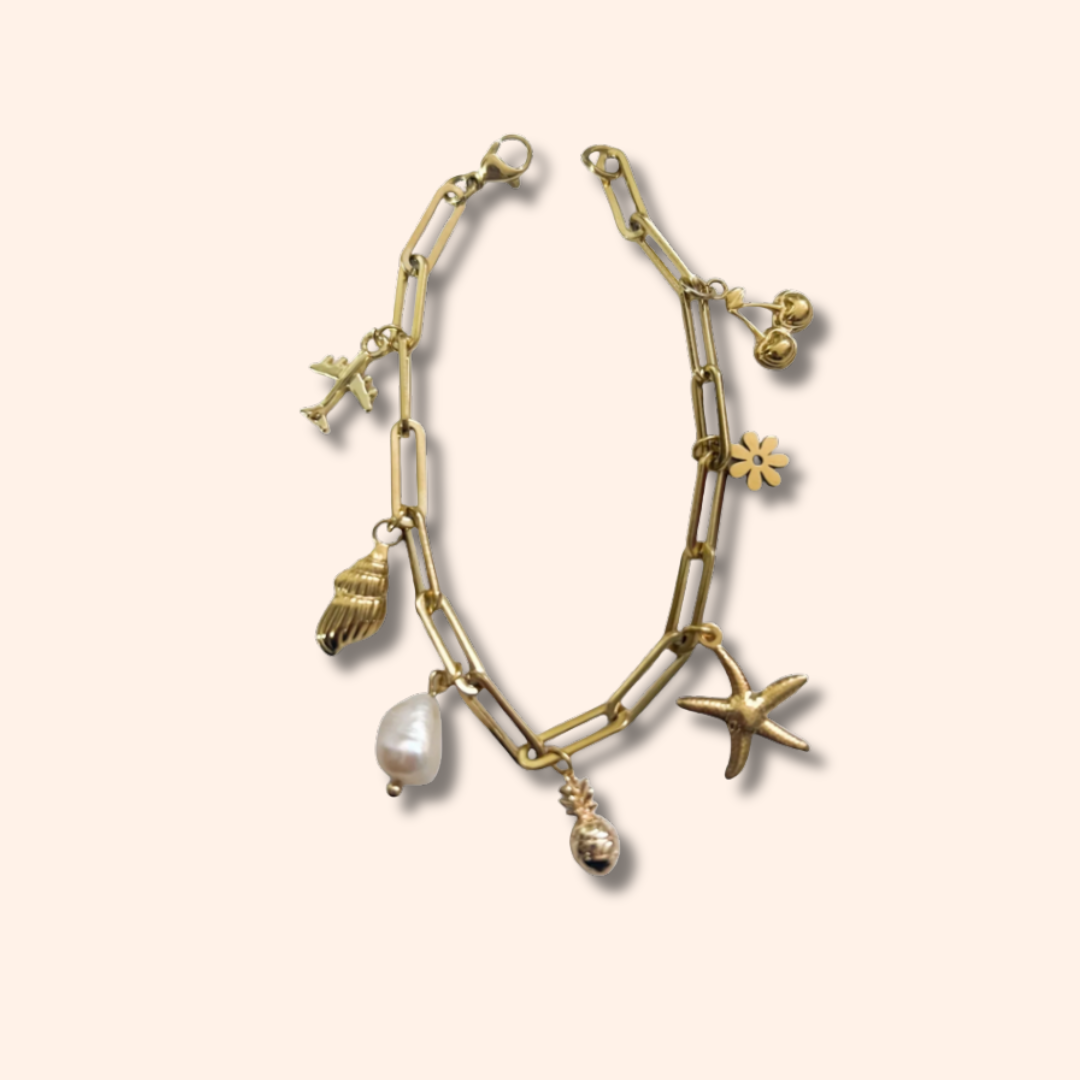 Gold bracelet with various charms on a beige background